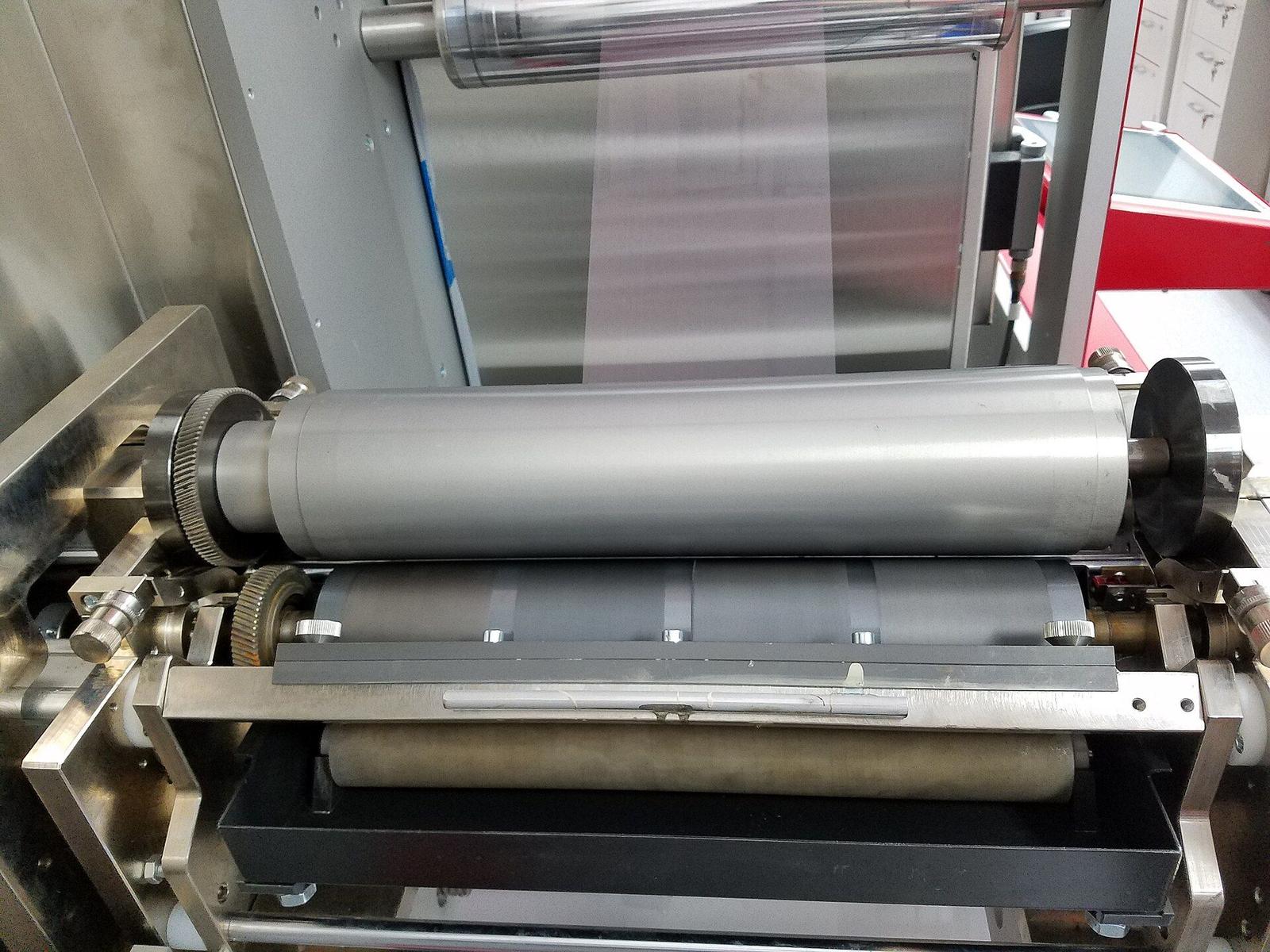 Print head of a flexographic roll-to-roll press: the anilox and print rollers with clear film running above